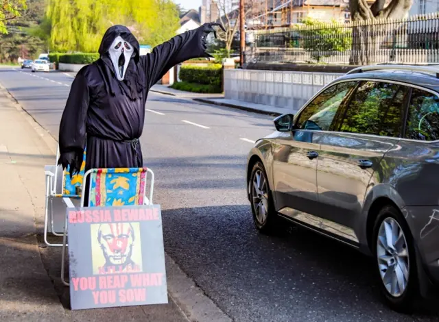 A protester dressed as the Grim Reaper stands outside the Russian Embassy in Dublin