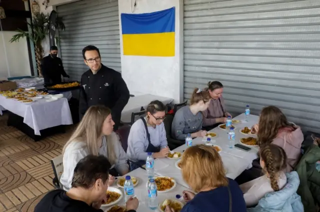 Spanish chef Ciriaco Vicente serves paella at his beach restaurant near Valencia to 11 Ukrainian refugees