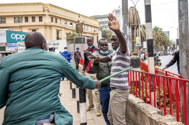 Kenyan police officer hitting a man during a protest