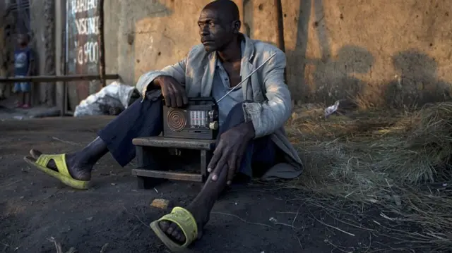 A man in Burundi listening to the radio in 2015