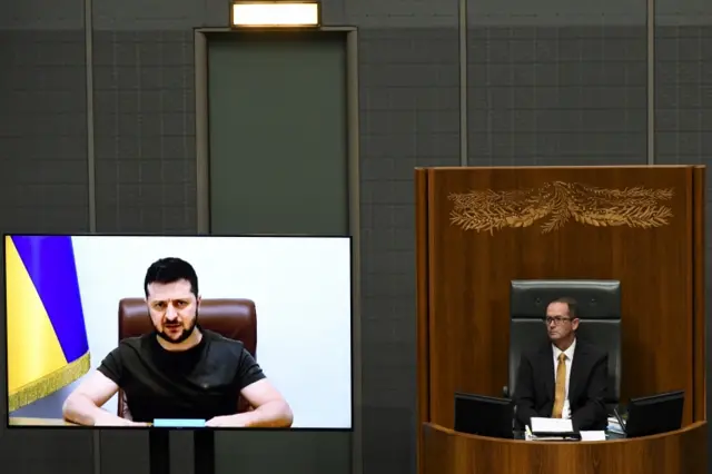 Agency epa09861433 Ukrainian President Volodymyr Zelensky (on screen) addresses Australian members of Parliament in the House of Representatives via video-link at Parliament House in Canberra, Australian Capital Territory, Australia, 31 March 2022