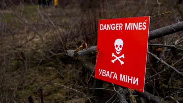 The red 'Danger Mines' sign is pictured during a military drill for civilians carried out by the Movement of the Veterans of Zakarpattia, Siurte village, Uzhhorod district, Zakarpattia Region, western Ukraine.