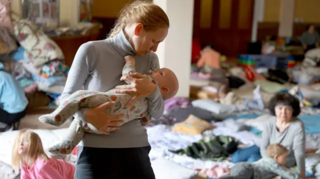 A mother holding baby in a Lviv refugee centre