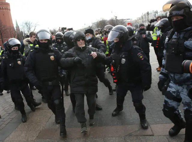 Russian Police officers detain a person during a unsanctioned protest rally at Manezhnaya Square in front of the Kremlin