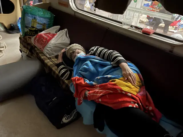 A woman sleeps inside a train carriage in Kharkiv's metro