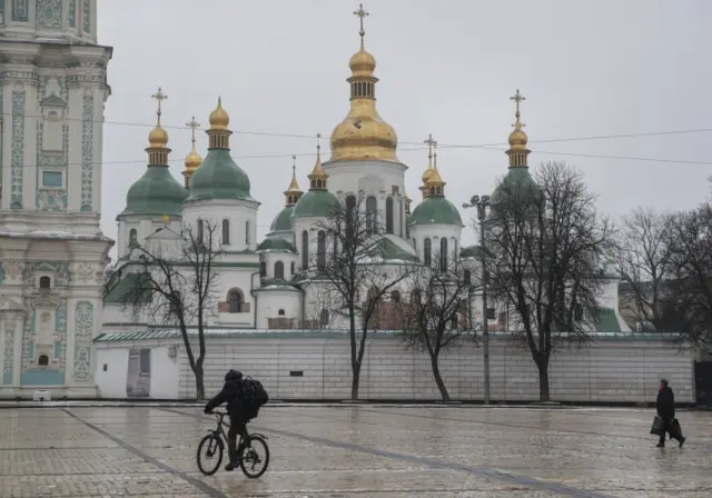 A man cycles outside the St. Sophia Cathedral in Kyiv