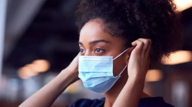 woman putting on mask