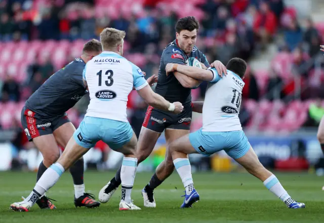 Johnny Williams of Scarlets is tackled by Kyle Steyn and Duncan Weir of Glasgow