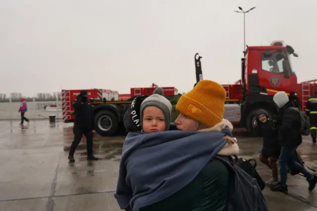 A woman carrying a child at the border crossing in Isaccea, Romania on 2 March