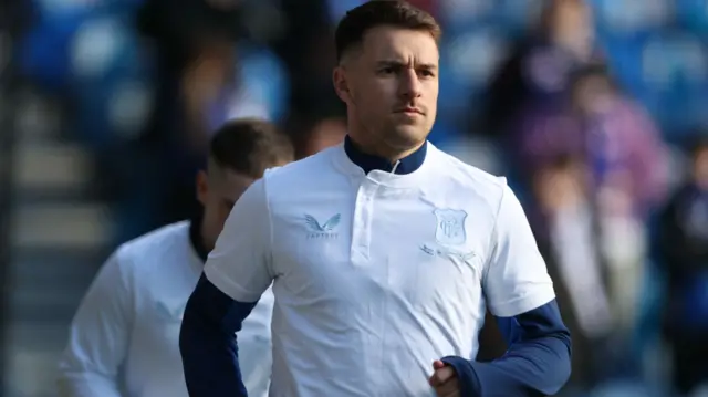 Aaron Ramsey, who starts on the Rangers bench, warms up at Ibrox