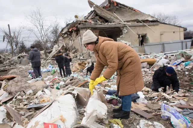 A woman stands amid the rubble in Markhalivka, Ukraine on 5 March