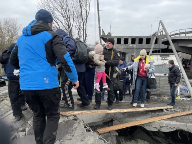 People crossing makeshift bridge to escape Irpin