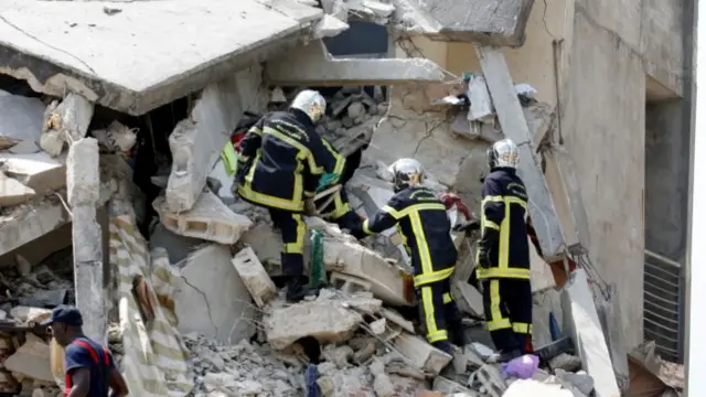 Firefighters search for survivors and bodies in the rubble of a collapsed apartment building in Abidjan, Ivory Coast March 7, 2022