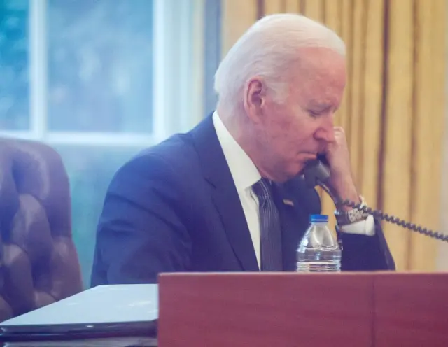 President Joe Biden in the Oval Office speaking by phone with President Zelensky