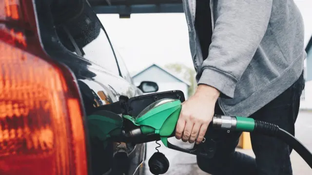 Person filling a car with petrol