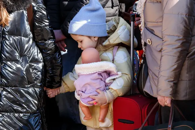 A little girl clutches a doll at a checkpoint on the Ukraine-Slovakia border