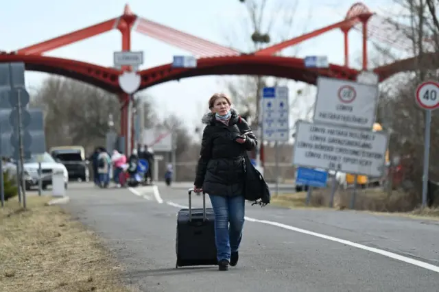 An Ukrainian refugee woman pulls her suitcase at Barabas, Hungary, close to the Hungarian-Ukrainian border on 2 March 2022.