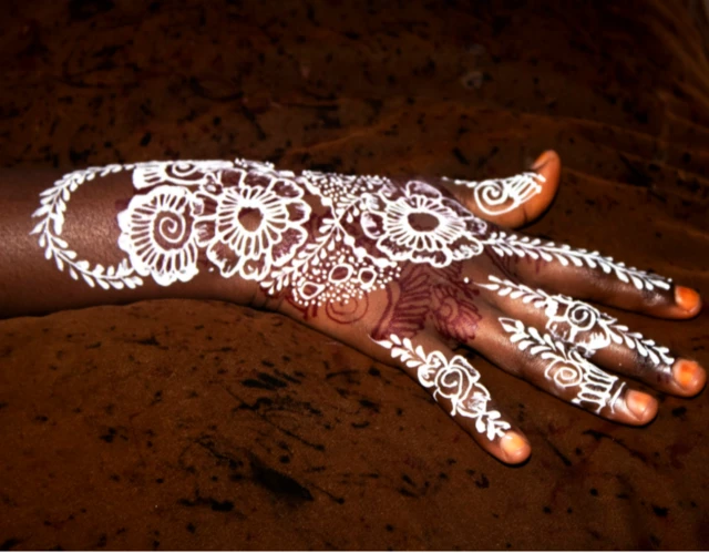 A young woman practicing henna art at a salon in Hodan District III by Falastin Khalif Yuusuf