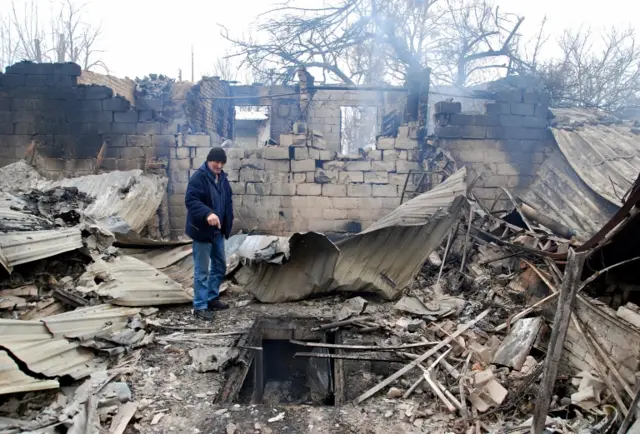 A man stands on the rubble of a house destroyed in Kharkiv. Photo: 7 March 2022