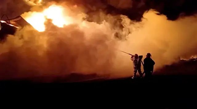 Fire fighters extinguish fire in an oil depot that Ukraine"s State Emergency Services say was caused by Russian strikes in Zhytomyr region, Ukraine