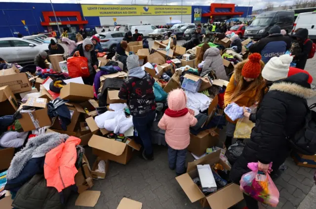 People fleeing the invasion of Ukraine, search for donated clothes at a transport hub in Przemysl, Poland