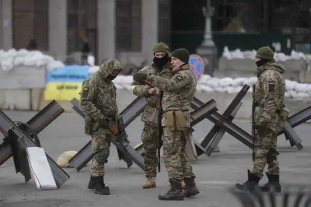 Ukrainian servicemen guard near a hedgehog barrier in Kyiv, Ukraine. Photo: 8 March 2022