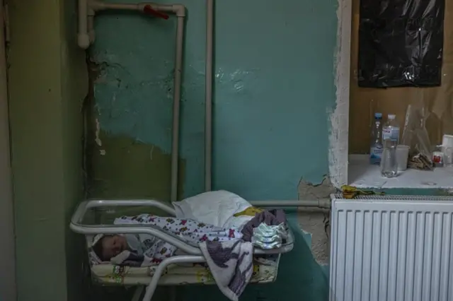 A newborn baby lays in a maternity hospital's basement in Kyiv, now used as a bomb shelter