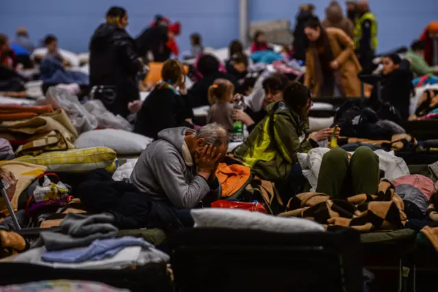 Ukrainian refugees rest in an abandoned supermarket in Poland