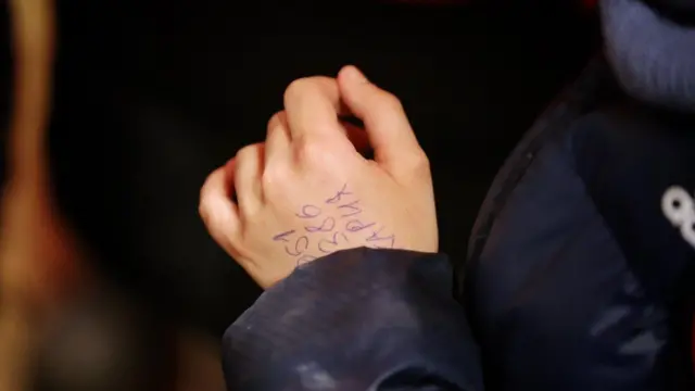 A phone number on the hand of Hassan