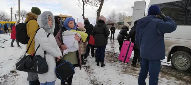 Women and children waiting to board evacuation buses from Sumy in north-eastern Ukraine