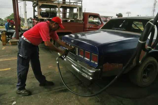 A Venezuelan man putting petrol in his car