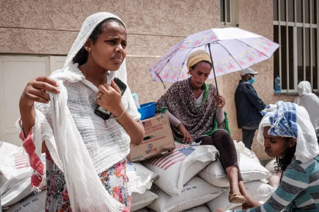 Women, who fled the violence in Ethiopia's Tigray region, wait to receive food during a food distribution organised by the local NGO Relief Society of Tigray (REST) in Mekele, the capital of Tigray region on June 22, 2021.