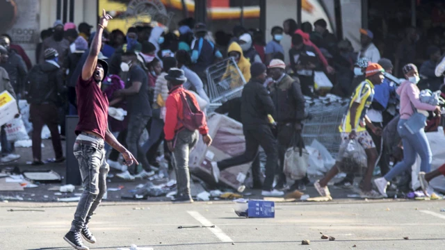 A man gestures as rioters loot the Jabulani Mall in the Soweto district of Johannesburg, South Africa - 12 July 2021