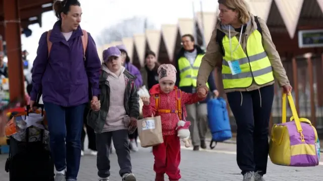 Ukrainian refugees walk on the platform after arriving on a train from Odesa at Przemysl Glowny train station, after fleeing the Russian invasion of Ukraine, in Przemysl, Poland