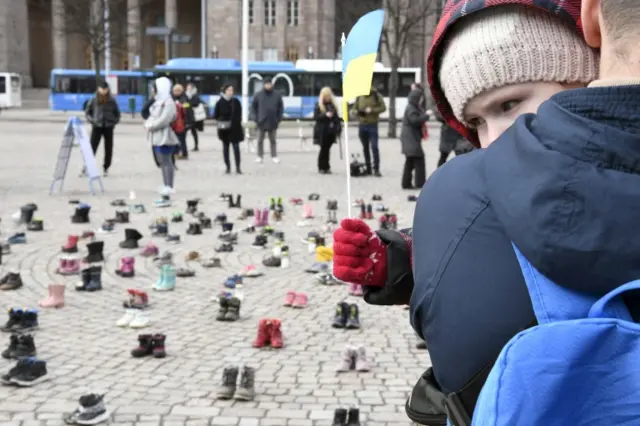 A child holds a Ukrainian flag during a demonstration organised by the Ukrainian Association in Finland to honour the memory of the children killed amid the Russian invasion in the Ukrainian city of Mariupol, in Helsinki, Finland