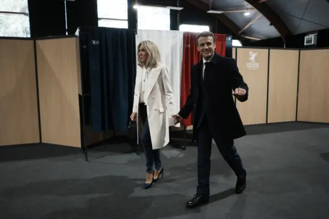 French President and centrist presidential candidate for re-election Emmanuel Macron and his wife Brigitte Macron arrive to vote for the first round of the presidential election, in Le Touquet, Northern France, 10 April 2022