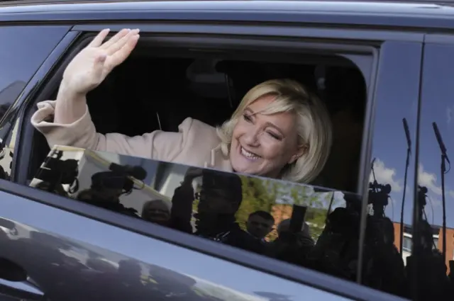 Marine Le Pen, leader of French far-right National Rally (Rassemblement National) party and presidential candidate, waves from a car as she leaves after voting in the first round of the 2022 French presidential election at a polling station in Hénin-Beaumont, France, on 10 April 2022