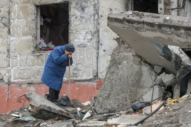 A woman cries as she tries to find a body of her son among debris of a residential building destroyed during Russia's invasion in the town of Borodyanka