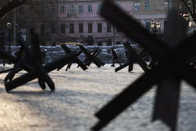 A girl skates past anti-tank traps in Odesa