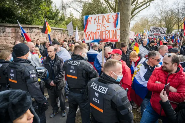 Protesters gather by a police cordon in Frankfurt