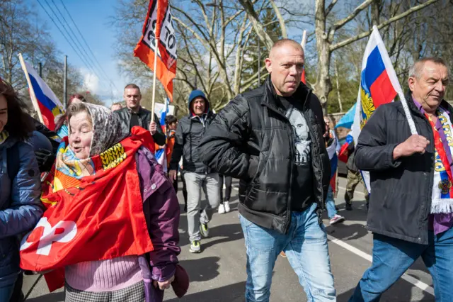 A man wears a t-shirt showing Vladimir Putin's face during a protest in Frankfurt