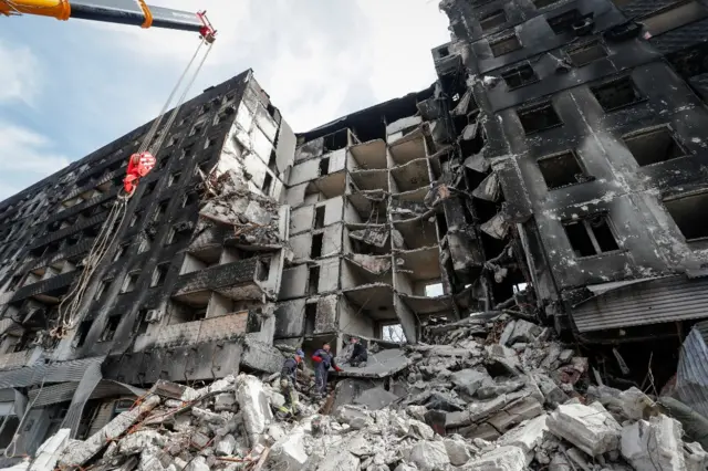 Emergency workers remove debris of a destroyed building in Mariupol