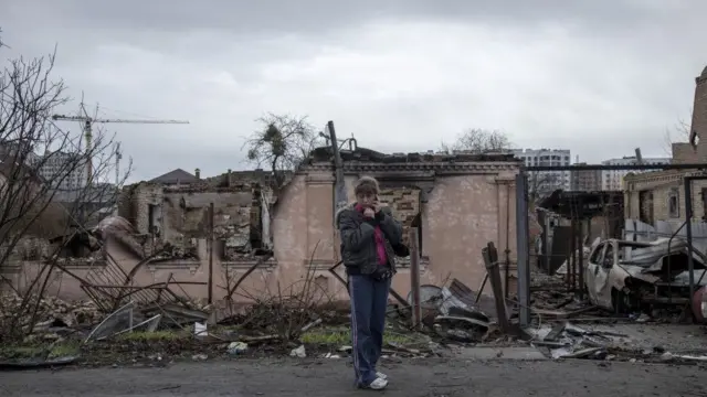 Woman surveys wreckage of Bucha near Kyiv