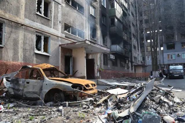 Destroyed buildings and a car in Mariupol