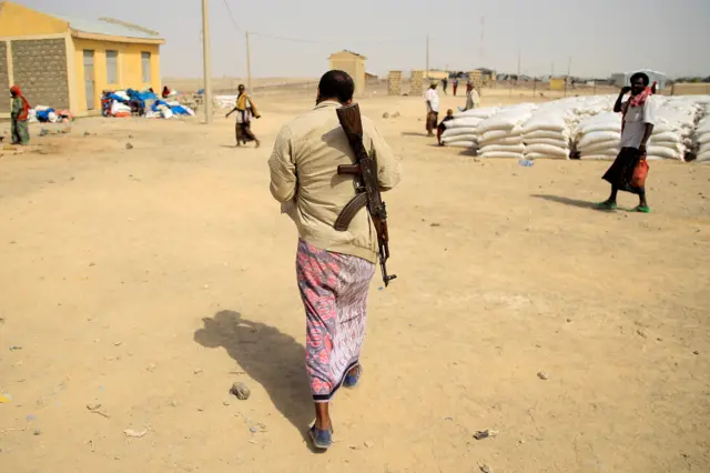 A militia member and guard walks through a camp for internally displaced people in Afdera town, Ethiopia, 23 February