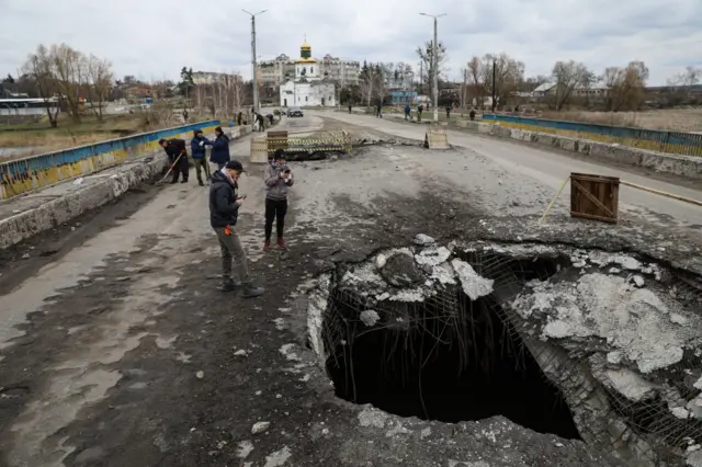 Road in the Makariv region near Kyiv with large hole created by shelling