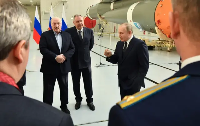 Belarusian President Alexander Lukashenko listens as Vladimir Putin speaks