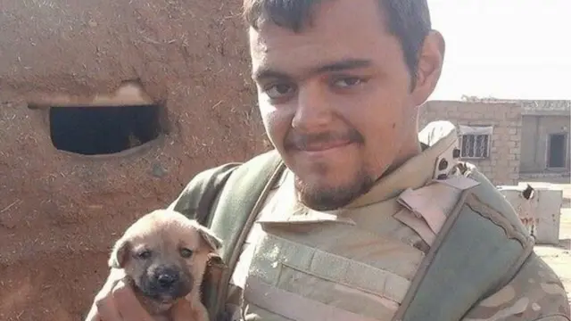 Aiden Aslin, photographed in Syria, holding a dog