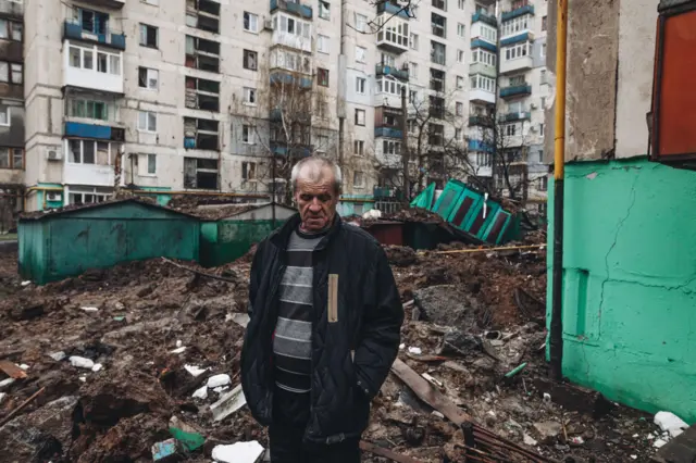 A man stands in wreckage