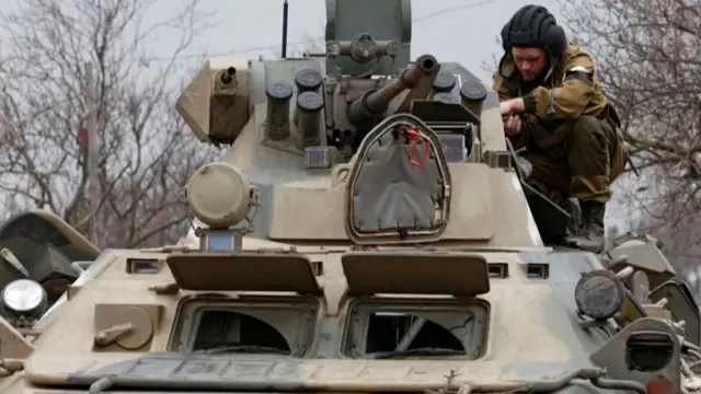 A service member of pro-Russian troops is seen on an armoured vehicle in Mariupol